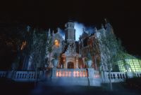A view of the Haunted Mansion inside the Magic Kingdom at night.